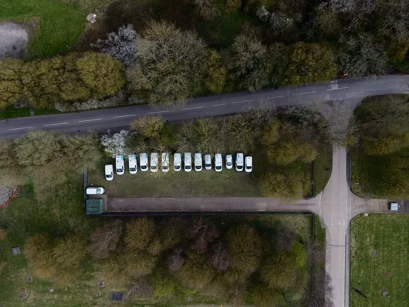 Aerial view of parked white vans along a road