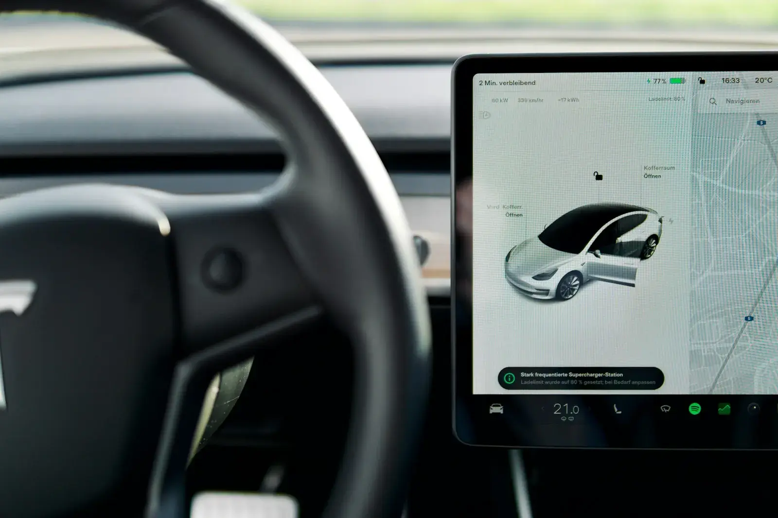 A car dashboard with a screen and a steering wheel