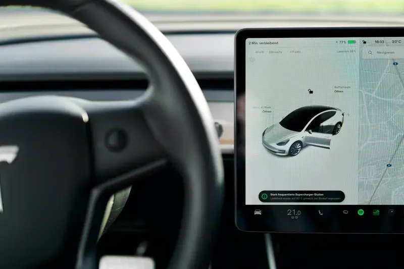 A car dashboard with a screen and a steering wheel